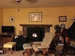 BEFORE--sitting area adjacent to kitchen w/ original red brick fireplace & yellow walls